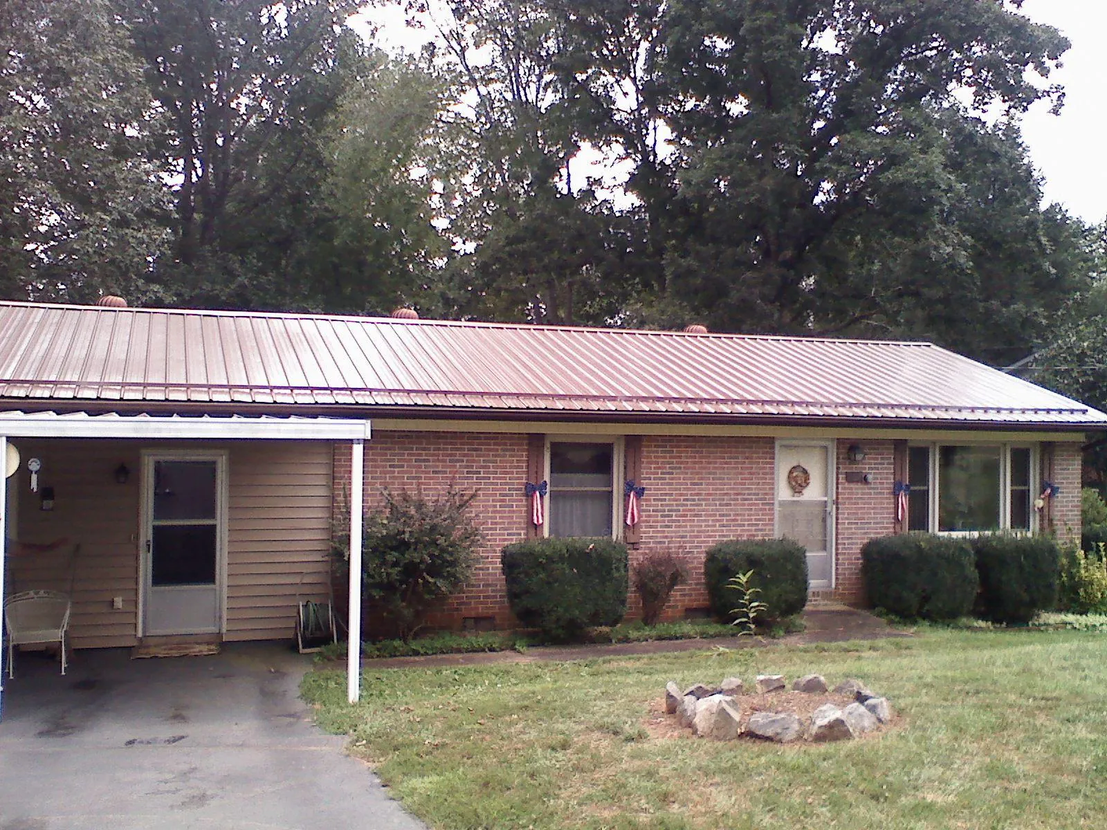 Bronze metal roof and carport on a brick ranch home — Roof Repair work by our crew in Amite