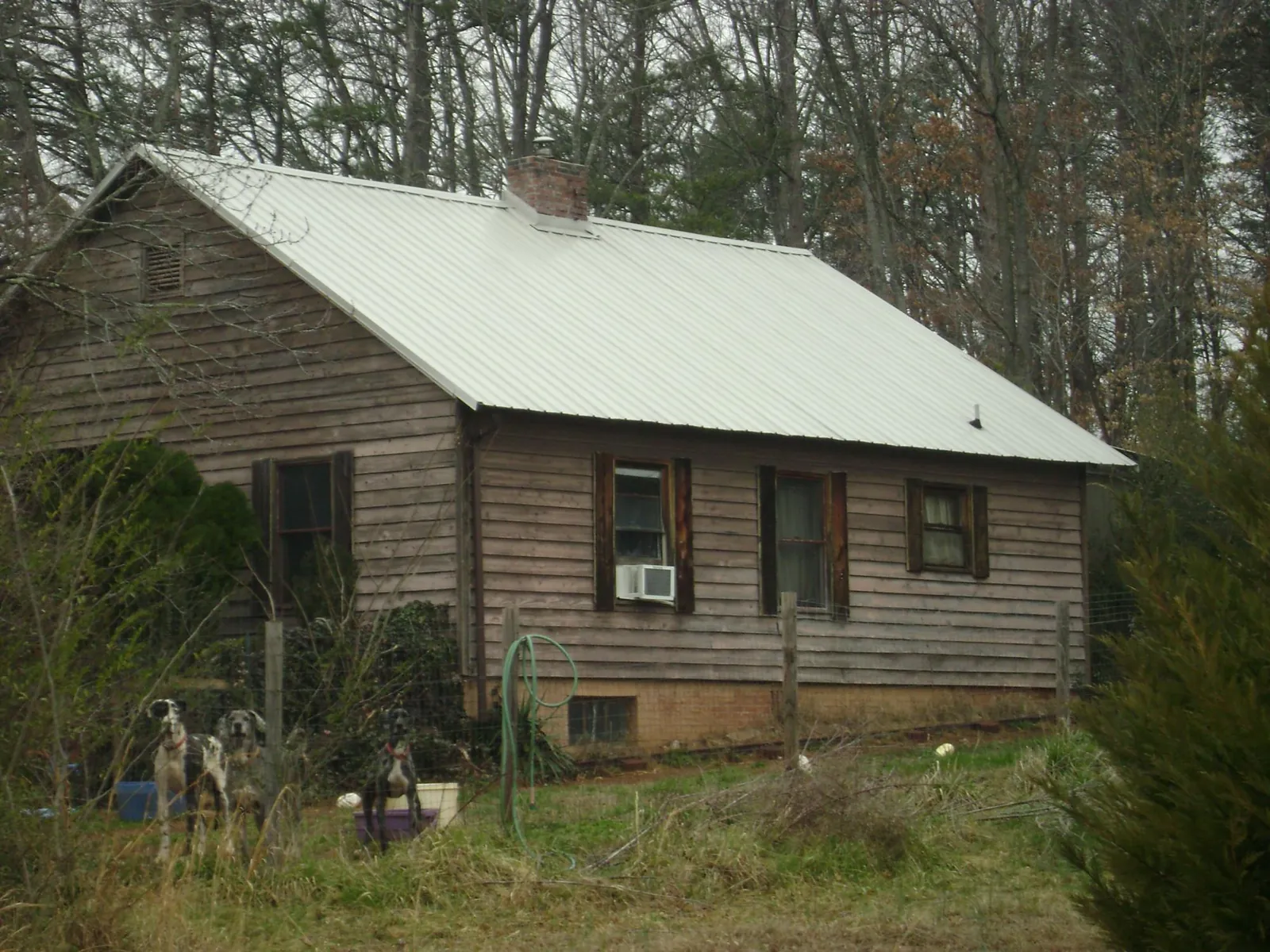 White metal roof on an old wood sided farmhouse, from a Metal Roof Installation job in Amite